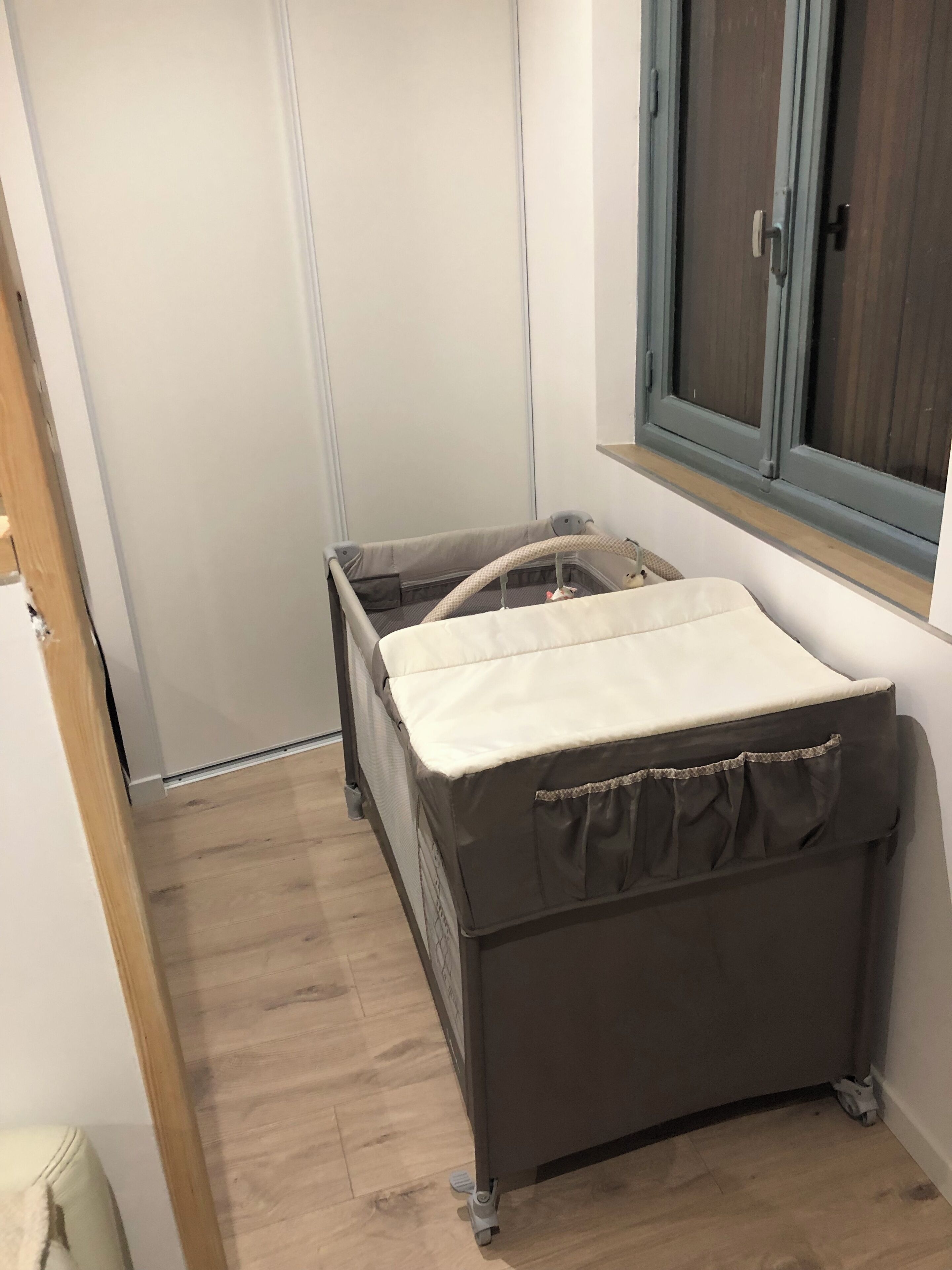 A compact room with a small bed, a cabinet, and a window.