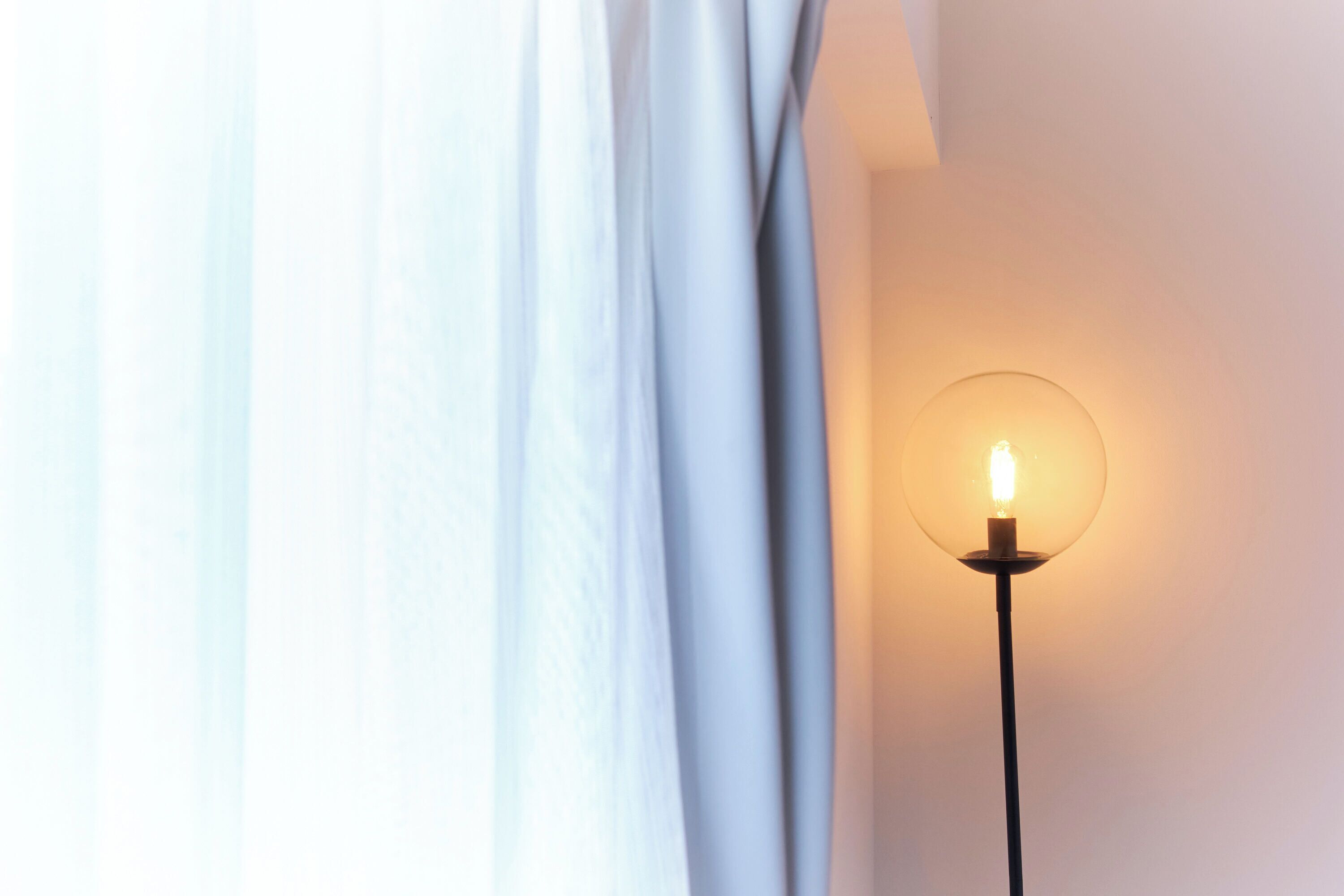 A wall-mounted lamp with a clear glass shade and a lit bulb.