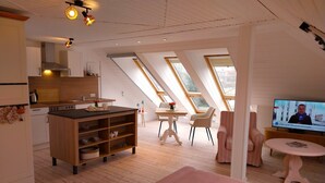 A modern loft with a kitchen, dining area, and living space. - Vacation apartment "Still Hörn 3" in Greetsiel (approx. 35 sqm / 2 persons) (Krummhörn)