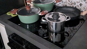 A kitchen with a stove, pots, and a backsplash. - Charming 1-bedroom house in adorable Putignano with WiFi, AC (Putignano)