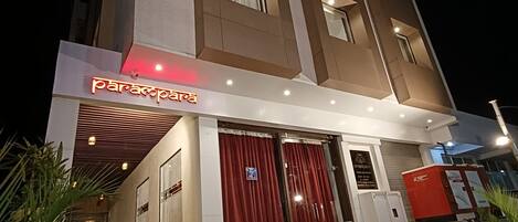 A multi-story hotel with a modern facade, featuring a prominent entrance with a red curtain and a sign that reads "paracopa".