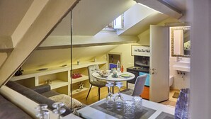 A cozy loft-style room with a dining area, a kitchen, and a bathroom. - BRERA - Tiny Studio (Milano)