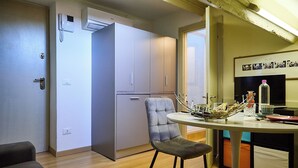 A compact kitchen with a dining table, a chair, and a refrigerator. - BRERA - Tiny Studio (Milano)