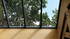 A room with a large window overlooking a tree.