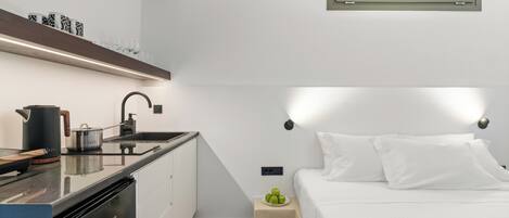 A compact bedroom with a bed, bedside table, and a small window.