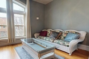 Una habitació amb un sofà, una taula de cafè de vidre i una finestra.