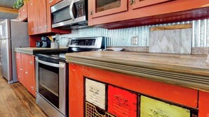 Una cocina con electrodomésticos de acero inoxidable, microondas y horno empotrado.