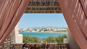 Una habitación con vistas a un paisaje costero, que incluye una playa y un faro.