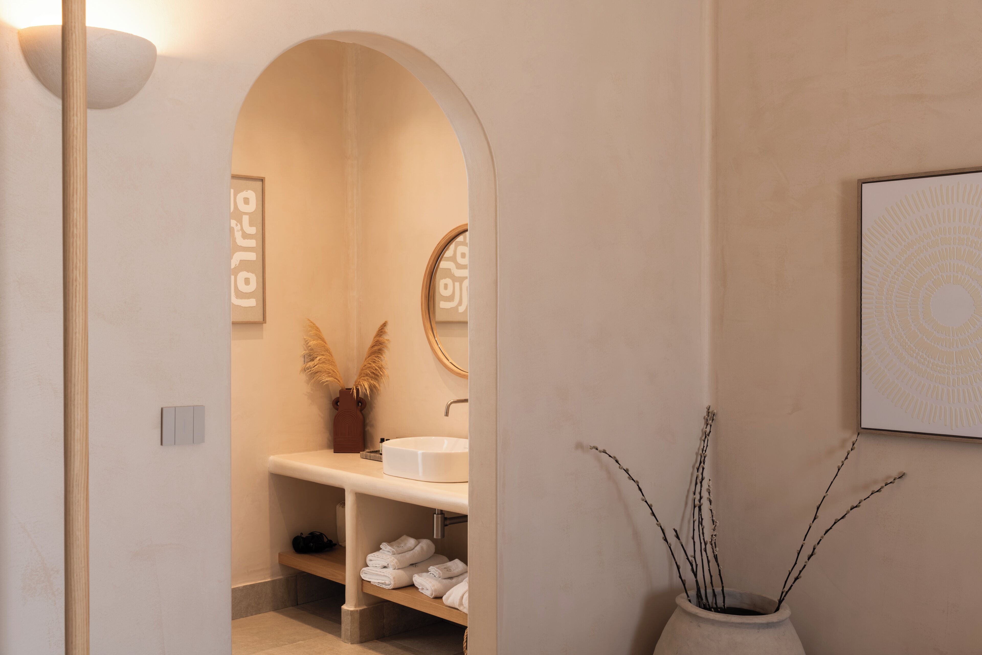 A modern bathroom with a white sink, a mirror, and a towel rack.