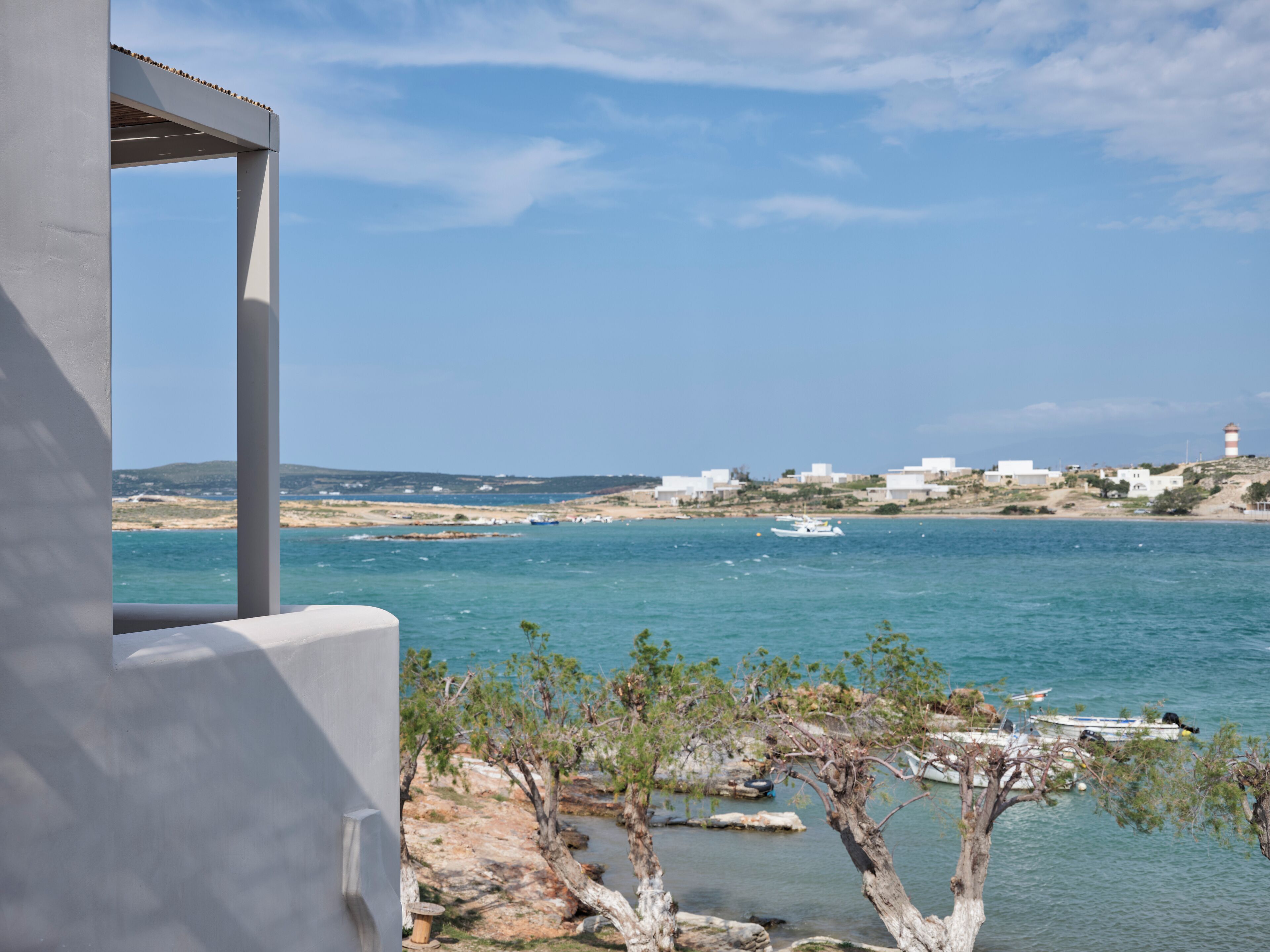 A coastal view with a clear sky, a body of water, and buildings in the distance.