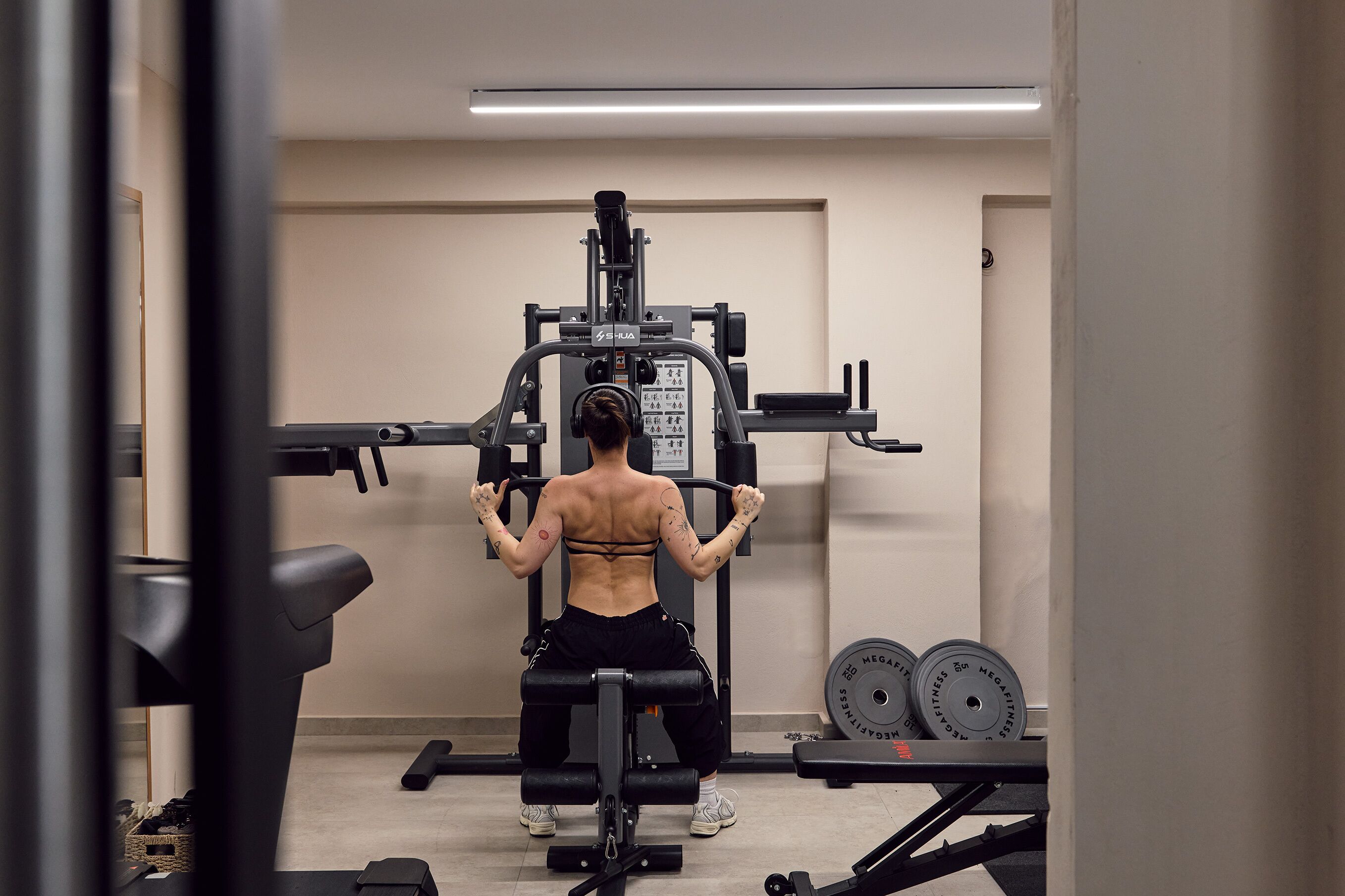 Uma academia com equipamentos de musculação, esteira e halteres.