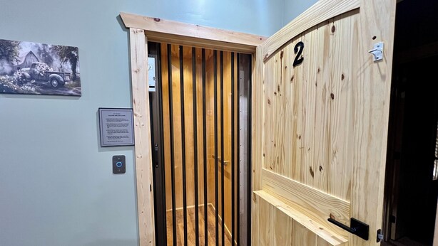 Een houten deur met verticale latten en het cijfer '2'.