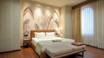 A spacious bedroom with a large bed, a nightstand, a bench, and a wall mural.