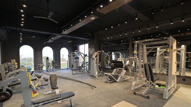 A spacious gym with various exercise machines, large windows, and a high ceiling. - Tree of Life Ganga Dwar, Haridwar (Haridwar)