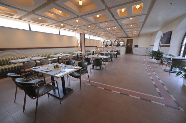 A spacious dining area with high ceilings, multiple seating options including booths and tables, and a central island. - Tree of Life Ganga Dwar, Haridwar (Haridwar)