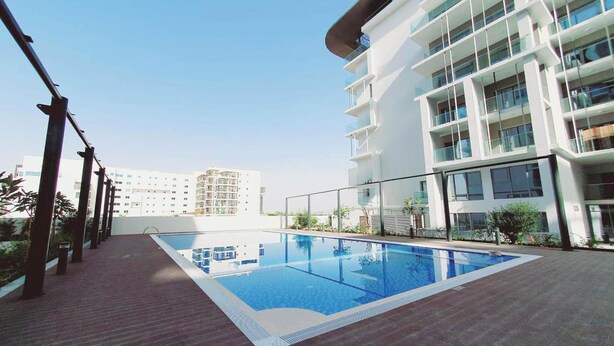 A rooftop swimming pool with a clear blue sky in the background. - Bloomfields Lavish STU in Oasis Masdar (Abu Dhabi)