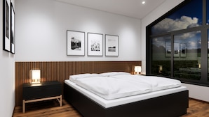 A modern bedroom with a large bed, wooden panel wall, bedside lamps, and framed pictures on the wall. - Bsundrix Wellness Tiny Vaya (Lorüns)