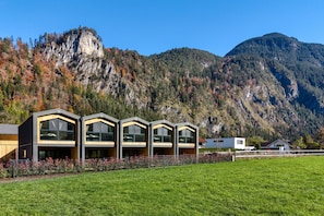 A modern building with a flat roof and large windows, set against a mountainous backdrop. - Bsundrix Living Tiny Skadi (Lorüns)