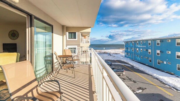 A balcony with a view of the beach and a building labeled "Windjammer."