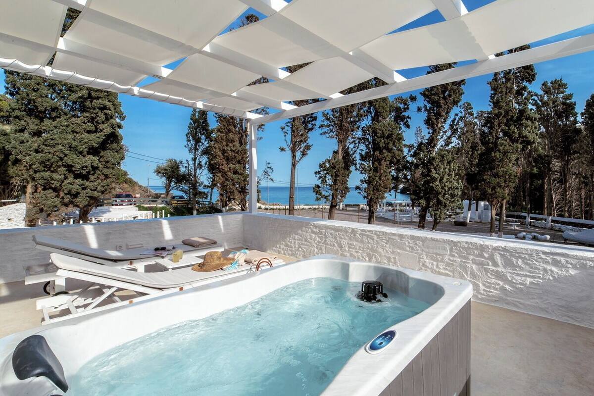Ein Wellnessbereich mit Whirlpool, Liegestühlen und Meerblick.