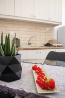 Una cocina con encimera, fregadero, armarios y una planta en maceta.