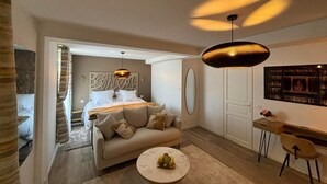Un dormitorio moderno con cama, sofá, escritorio y zona de comedor.
