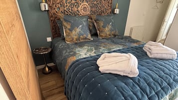 Une chambre à coucher avec un grand lit, une tête de lit en bois et un panneau décoratif mural.