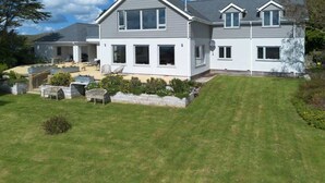 A two-story house with a well-maintained lawn and outdoor seating area.