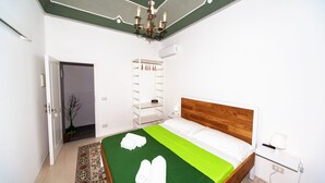 Ein ordentlich eingerichtetes Hotelzimmer mit Bett, Nachttisch, Lampe und Kleiderschrank.