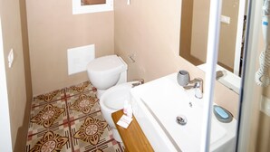Ein kleines Badezimmer mit Toilette, Waschbecken und Dusche.