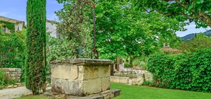 Escape to a serene garden oasis with lush greenery, a tranquil planter, and a cozy seating area.