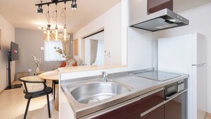 Una cucina moderna con una grande isola, elettrodomestici in acciaio inossidabile e lampade a sospensione.