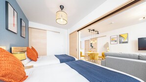 Una camera d'albergo moderna con un letto, un divano, un'area pranzo e opere d'arte alle pareti.