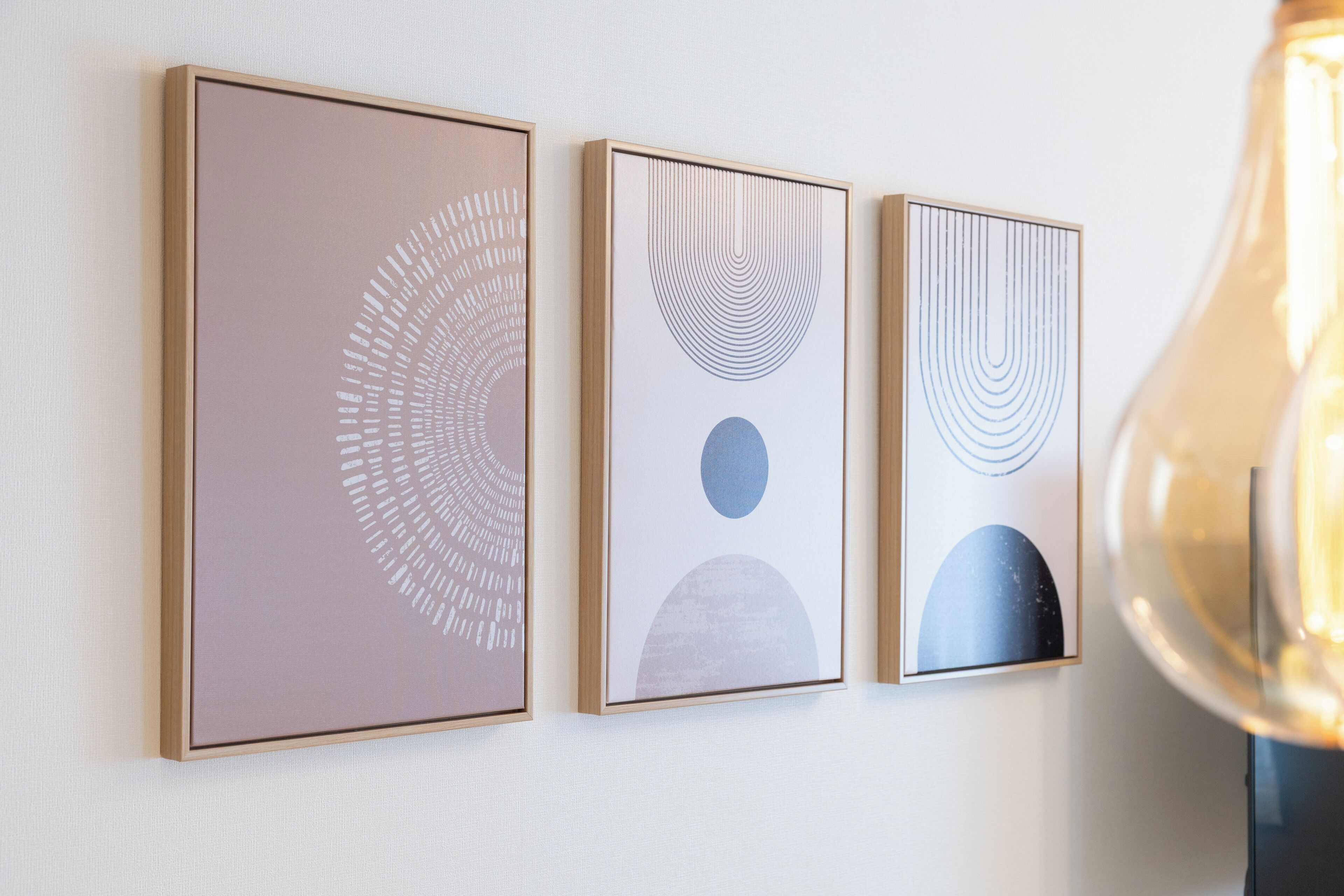 Three framed artworks on a wall.