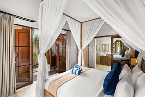 Una camera da letto con un letto grande, tende bianche e vista sull'esterno.