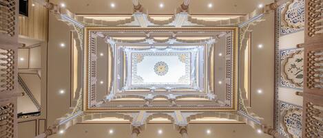 A grand, symmetrical interior with ornate columns and a central decorative element.