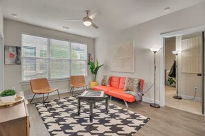 Un salon moderne comprenant un canapé, deux fauteuils, une table basse et un lampadaire.