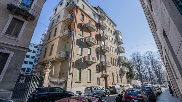 A multi-story building with balconies, parked cars, and a clear sky. - Studio Gar by Wonderful Italy (Turin)