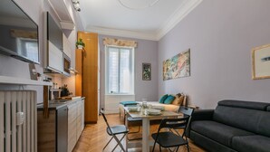 A modern living space with a dining area, a sofa, and a kitchen. - Studio Gar by Wonderful Italy (Turin)