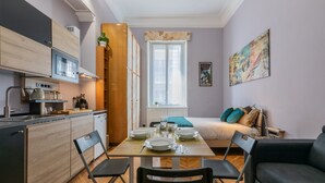 A compact living space with a kitchen, dining area, and a bed. - Studio Gar by Wonderful Italy (Turin)