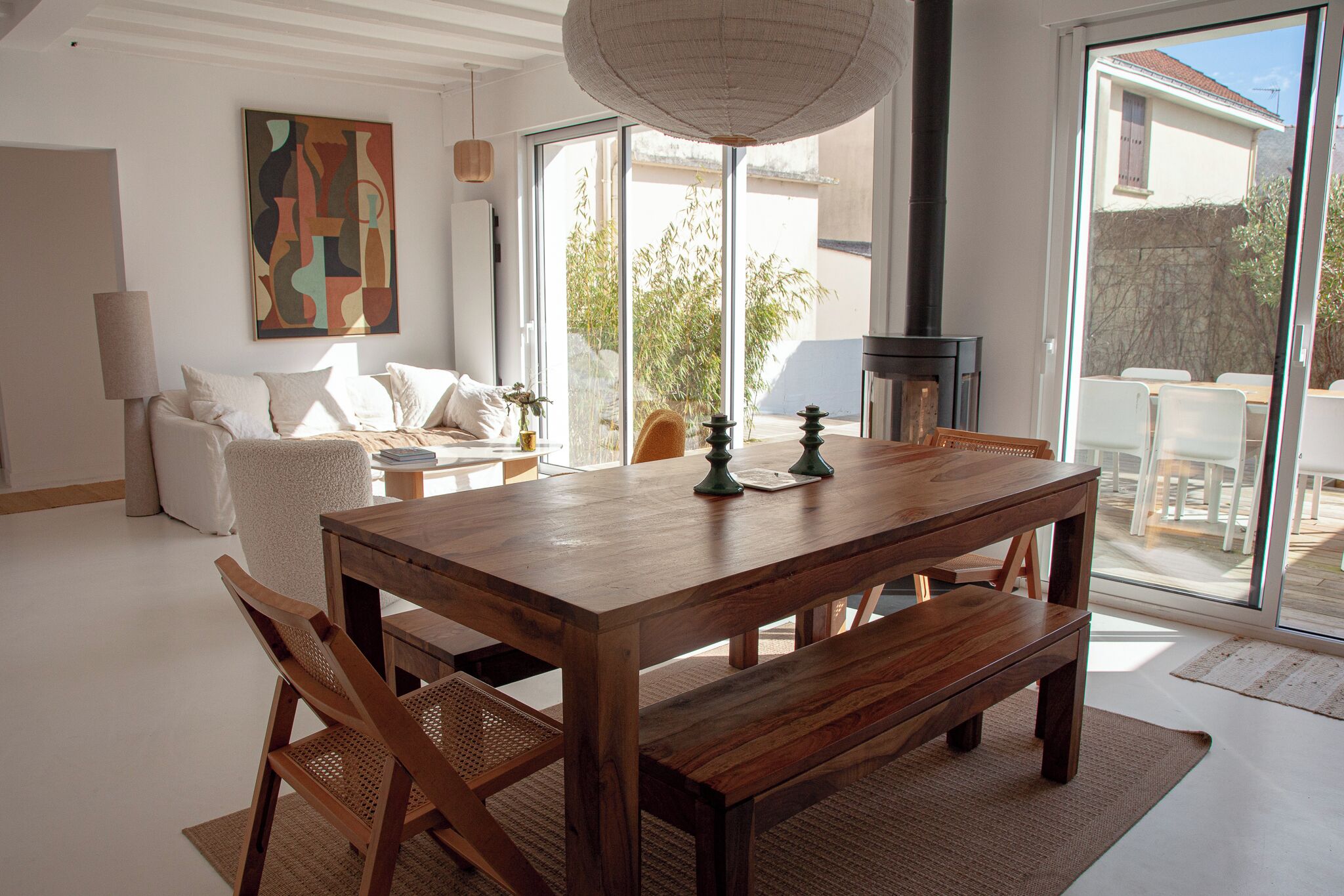 Un salón amplio con una mesa de comedor de madera, asientos cómodos y un ventanal con vistas al exterior.