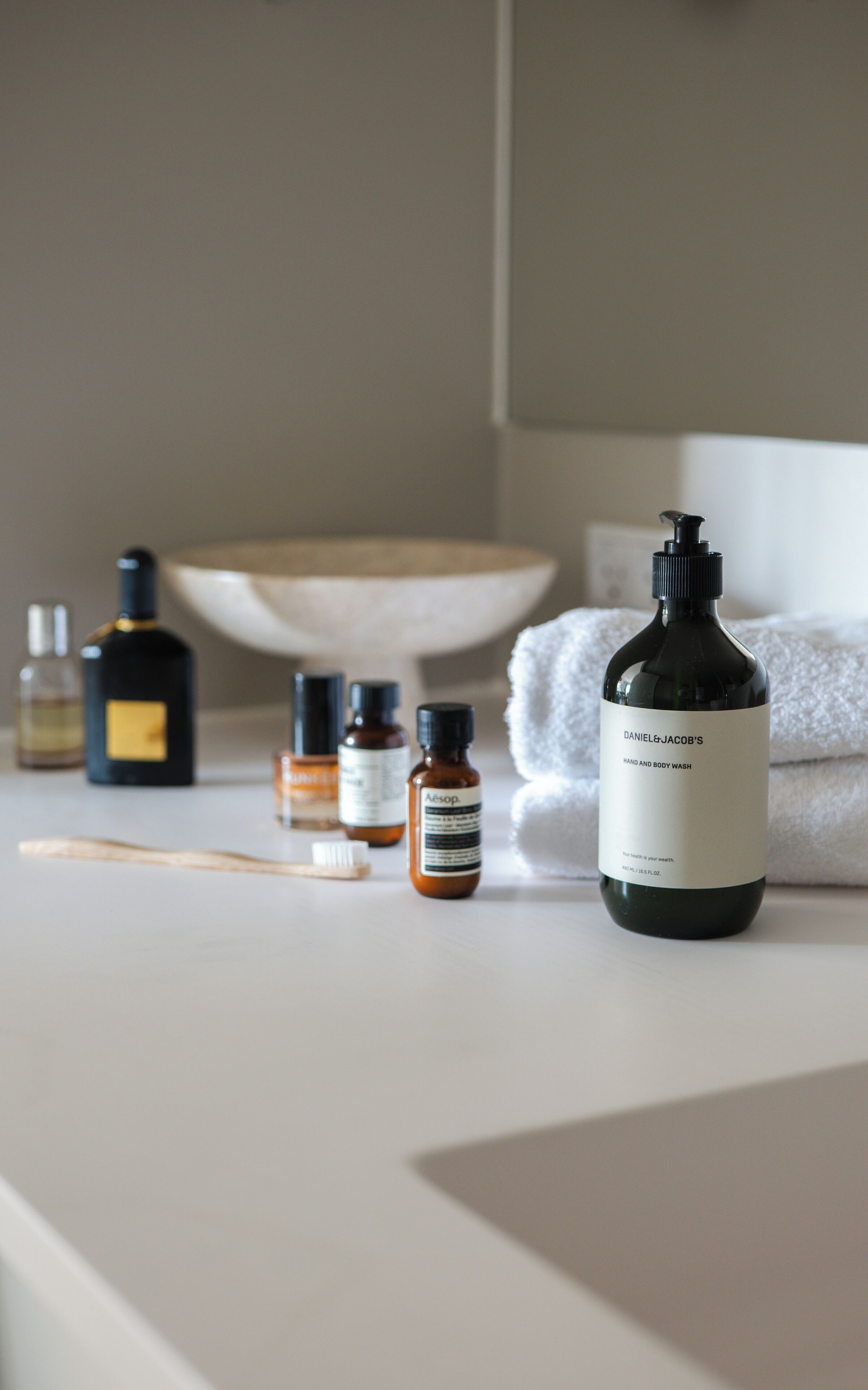 A bathroom counter with various toiletries including a bottle labeled "Daniel & Jacob's Hand and Body Wash".
