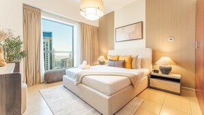 Een moderne slaapkamer met een groot bed, een nachtkastje, een raam met gordijnen en uitzicht op de stad.