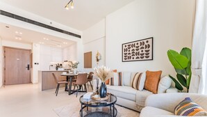 Un salon moderne comprenant un canapé, une table basse et un coin repas avec des chaises et une table.