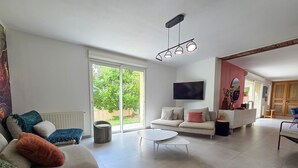 A modern living room with a sofa, a coffee table, and a TV mounted on the wall.