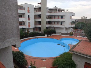 A multi-story building with a swimming pool area.