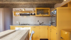A kitchen with yellow cabinets, a wooden countertop, and a vintage refrigerator. - Yellow Home by MMega (Florence)