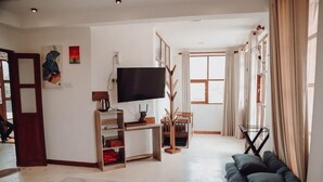 A modern living room with a flat-screen TV, a sofa, a coffee table, and a large window with curtains. - Affinity Villa Dikoya (Dick oya)