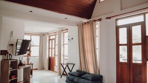 A spacious room with a large bed, a TV, and a wooden ceiling. - Affinity Villa Dikoya (Dick oya)