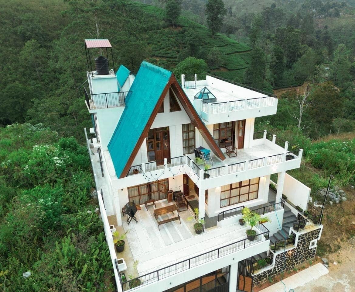 A multi-story house with a sloped roof, balconies, and a terrace.